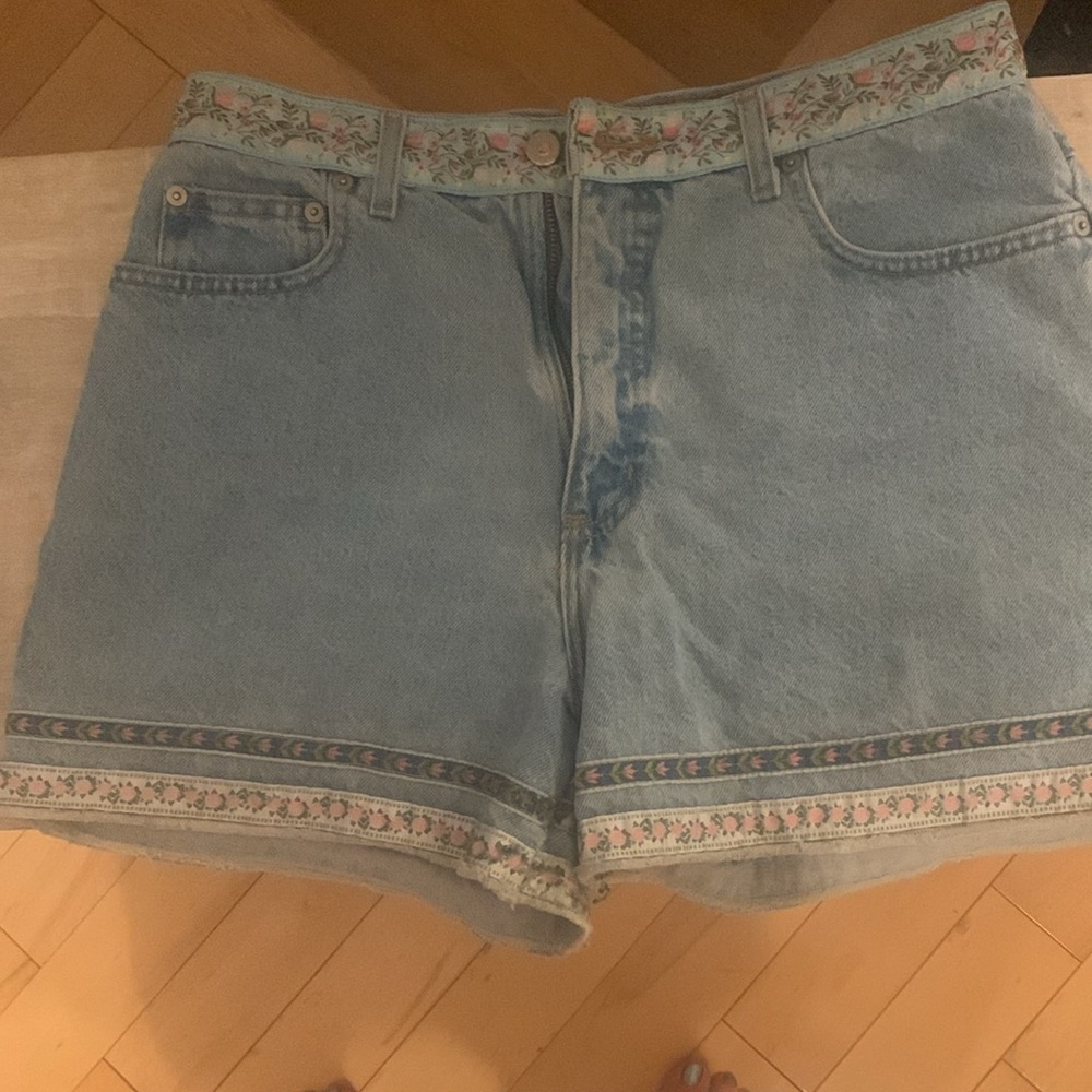 Pretty jean shorts with flower hem and decorative pockets. Nice flower details!